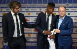 La recrue lyonnaise Thiago Mendes (c) entourée du directeur sportif de l'OL Juninho (g) et du président Jean-Michel Aulas, le 3 juillet 2019 à Décines-Charpieu