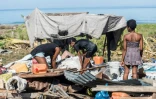 Des habitants de Port-à-Piment, à Haïti, dégagent les décombres de ce qui reste de leur maison, le 16 août 2021 