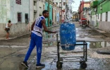 Un homme collecte de l'eau potable à un point de ravitaillement public dans une rue de La Havane, le 6 octobre 2026