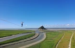 Le funambule Nathan Paulin sur une slackline de 2.200 mètres de long reliant une grue à l'abbaye du Mont Saint-Michel, le 24 mai 2022