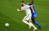 L'attaquant du Real Madrid Karim Benzema (g) à la lutte avec le défenseur de Getafe Allan Nyom, le 2 juillet 2020 à Valdebebas, dans la banlieue de Madrid 