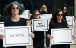Des proches d'otages peut-être morts à Gaza portent des pancartes avec leurs noms, le 31 janvier 2025 à Tel Aviv