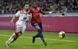 Le défenseur de Lille Youssouf Koné (d) à la lutte avec le Lyonnais Léo Dubois en championnat, le 5 mai 2019 à Décines-Charpieu