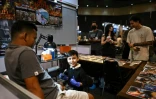 Napat Mitmakorn, 9 ans, travaille sur le tatouage de son oncle lors de la 2025 Thailand Tattoo Expo à Bangkok, le 15 mars 2025 en Thaïlande