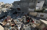 Des Palestiniens recherchent des survivants dans les décombres d'un bâtiment touché par une frappe israélienne à Bureij, dans le centre de la bande de Gaza, le 2 mai 2025
