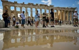 Des touristes visitent le site antique de l'Acropole, le 14 juin 2023 à Athènes