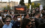 Des photos des incendies de forêt lors d'une manifestation contre la nouvelle loi environnementale en discussion au parlement grec, le 28 juillet 2022 à Athènes 