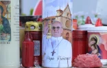 Des bougies déposées au pied de la statue de Jean-Paul II devant l'hôpital Gemelli à Rome où est hospitalisé le pape François, le 2 mars 2025