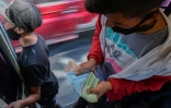Un vendeur de tickets compte sa recette dans un autobus Ă Caracas, le 29 janvier 2021
