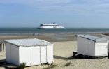 Un ferry passe au loin de Blériot-Plage et ses chalets, le 16 août 2021