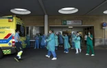 Des personnels soignants applaudissent à l'arrivée d'une ambulance devant l'enrée de l'hôpital Virgen del Rocio, le 17 mai 2020 à Séville, en Espagne