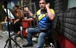 Gerry Mutia produit les effets sonores pendant l'enregistrement d'un feuilleton radiophonique dans le studio d'une station de radio Ă Manille, le 17 juillet 2023 aux Philippines