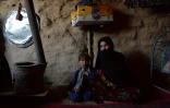 Sabehreh (d) et sa fille Zakereh, 3 ans, vendue au fils de l'épicier pour payer leurs dettes, sous une tente du camp de déplacés de Qala-i-Naw, le 14 octobre 2021 en Afghanistan