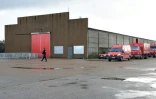 Un membre de la sécurité civile passe devant un hangar qui servira à rassembler les migrants après leur évacuation de la "Jungle" de Calais, le 22 octobre 2016