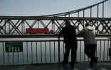 Un camion transportant des marchandises passe sur le pont de l'amitié sino-coréenne, reliant la ville frontalière chinoise de Dandong, à la ville nord-coréenne de Sinuiju, le 26 mars 2026