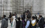 Des touristes visitent le Taj Mahal et passent devant des échafaudages installés pour rénover le monument, à Agra en Inde, le 3 janvier 2018
