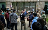 Un employé parle aux gens devant l'entrée d'une banque à Shanghai après la levée de nombreuses restrictions anti-Covid, le 1er juin 2022