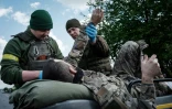 Des membres des forces ukrainiennes évacuent un blessé près de Lyssytchansk et du front de l'est ukrainien, le 10 mai 2022