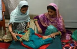 La jeune Indienne Geeta, sourde et muette, aidée par une amie, prépare ses valises qu'elle remplit de cadeaux et de vêtements pour ses proches avant son départ en Inde, le 22 octobre 2015 à la fondation Edhi à Karachi, au Pakistan