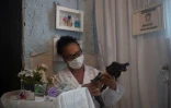 Suelen da Silva vérifie une des poupées qui lui a été confiée pour être "soignée" dans son hôpital de poupées, à Niteroi près de Rio de Janeiro, le 10 décembre 2020