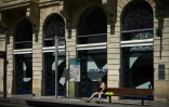 Un homme assis sur un banc Ă une station de tramway, le 28 juillet 2024 Ă Bordeaux