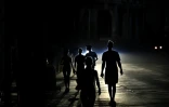 Des habitants marchent dans une rue de La Havane pendant une panne d'électricité, le 13 mai 2026 à Cuba