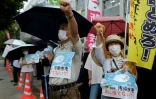 Des manifestants brandissent des pancartes contre le projet du gouvernement japonais de rejeter dans l'océan les eaux traitées de la centrale de Fukushima Daiichi, devant le bureau du premier ministre à Tokyo, le 22 août 2023