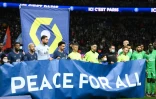 Les joueurs du Paris Saint-Germain et de Saint-Etienne posent derrière une banderole portant les mots "Paix pour tous", avant le début de leur match de la 26e journée de Ligue 1, le 26 février 2022 au Parc des Princes