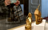 Une visiteuse de l'exposition "Aux pieds des dieux" photographie une paire de chaussures au Palais Pitti de Florence, le 30 janvier 2020 en Italie