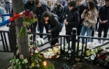 Ues personnes déposent des fleurs et des bougies à la mémoire des victimes d'une fusillade à l'école Vladislav Ribnikar, le 4 mai 2023 à Belgrade, en Serbie