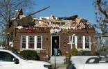 Un habitant devant une maison dévastée par le passage d'une tornade, à Bowling Green, dans le Kentucky, le 12 décembre 2021