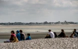 Des gens assis sur la plage dans la baie de Somme au Hourdel, le 5 août 2016