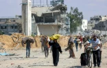 Des Palestiniens marchent sur une route dans le centre de Khan Younès, dans le sud de la bande de Gaza, le 10 octobre 2025.

