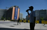 Un homme boit de l'eau, à l'ombre près du bâtiment de la Commission européenne, lors d'une vague de chaleur à Bruxelles, le 25 juin 2026