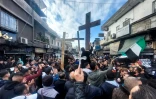Des Syriens chrétiens brandissent des croix lors d'un rassemblement dans un quartier de Damas, le 24 décembre 2024