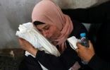 Une Palestinienne pleure en tenant le corps enveloppé d'un bébé tué dans une frappe israélienne selon les secours locaux sur le quartier de Choujaïya à Gaza-ville, le 9 avril 2025