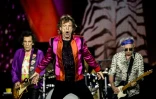 Le chanteur Mick Jagger (c) entre les guitaristes Ron Wood (g) et Keith Richards lors d'un concert des Rolling Stones à Décines-Charpieu, dans la banlieue de Lyon, le 19 juillet 2022