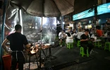 Des clients attablés dans un restaurant de rue, le 29 avril 2026 à Bangkok 