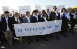 Ghyslain Wattrelos (3e à d), proche de victimes du vol MH370 de la Malaysia Airlines qui a disparu en mars 2014, en tête d'une marche silencieuse vers le Palais de l'Elysée à Paris, le 8 mars 2015