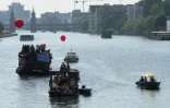 Des militants antifascistes naviguent à bord d'embarcations sur la rivière Spree à Berlin en direction de la gare centrale pour contrer une manifestation du parti d'extrême-droite AfD, le 27 mai 2017 en Allemagne