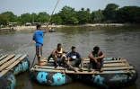 Le migrant vénézuélien Gilberto (g) et son chien Negro traversent le fleuve Suchiate entre Tecun Uman, au Guatemala, et Cuidad Hidalgo, au Mexique, le 17 mai 2022