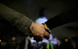 Des gens se tiennent la main devant un mémorial improvisé place de la République à Paris le 20 novembre 2015
