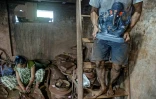 Dans l'atelier du potier Yusuf Zakaria Galwani au bidonville de Dharavi, à Bombay, un artisan porte le 15 août 2020 une statuette en terre cuite du dieu hindou Ganesh