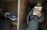 Un combattant taliban brandit le livre "Not a good day to die" ("Pas un bon jour pour mourir"), dans un ex-camp de l'armée américaine dans l'aéroport de Kaboul, le 14 septembre 2021