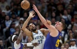 Le double MVP des Denver Nuggets, Nikola Jokic (D), à la lutte pour le ballon avec le pivot français des Minnesota Timberwolves Rudy Gobert, le 29 mars 2024 à Denver