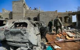 Des rebelles houthis inspectent le site d'une frappe aérienne américaine à Sanaa, un jour après l'attaque, le 7 avril 2025