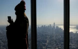 Une touriste prend des photos depuis les hauteurs de l'Empire State à New York, le 9 novembre 2021, au lendemain de la réouverture des frontières américaines aux touristes étrangers, notamment européens