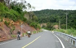 Des motocyclistes sur une route du parc national des Cardamomes, dans la province de Koh Kong, le 11 juin 2026 au Cambodge