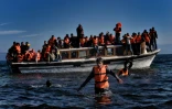 Des migrants et réfugiés arrivent en bateau sur l'île grecque de Lesbos, le 26 octobre 2015 après avoir traversé la mer Egée depuis la Turquie