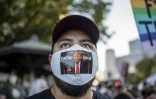 Un homme porte un  masque sur lequel est écrit "You're Fired Trump" ("Vous êtes viré Trump"), le 7 novembre 2020 à Austin au Texas